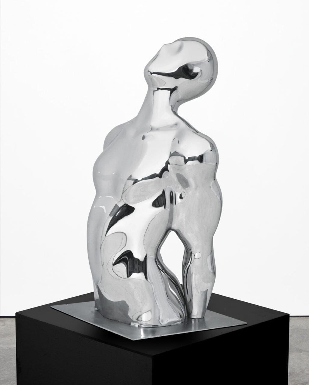 Polished stainless steel abstract torso sculpture by Masoud Akhavanjam with smooth reflective surface.