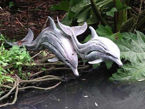 Bronze resin sculpture “Leaping Dolphins” by Edwin Russell, depicting dolphins in dynamic motion and harmony.