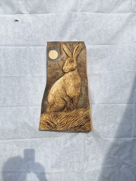 Wooden hare sculpture by Simon Archer depicting a moonlit hare in a simplified carved form.
