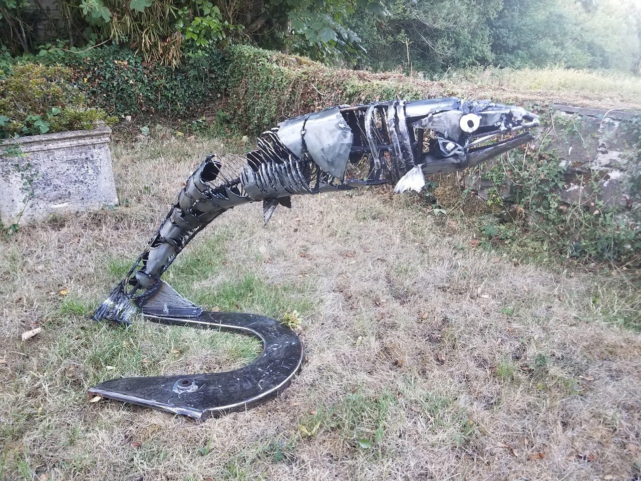 Contemporary recycled steel salmon sculpture leaping upward by Myles Mansfield