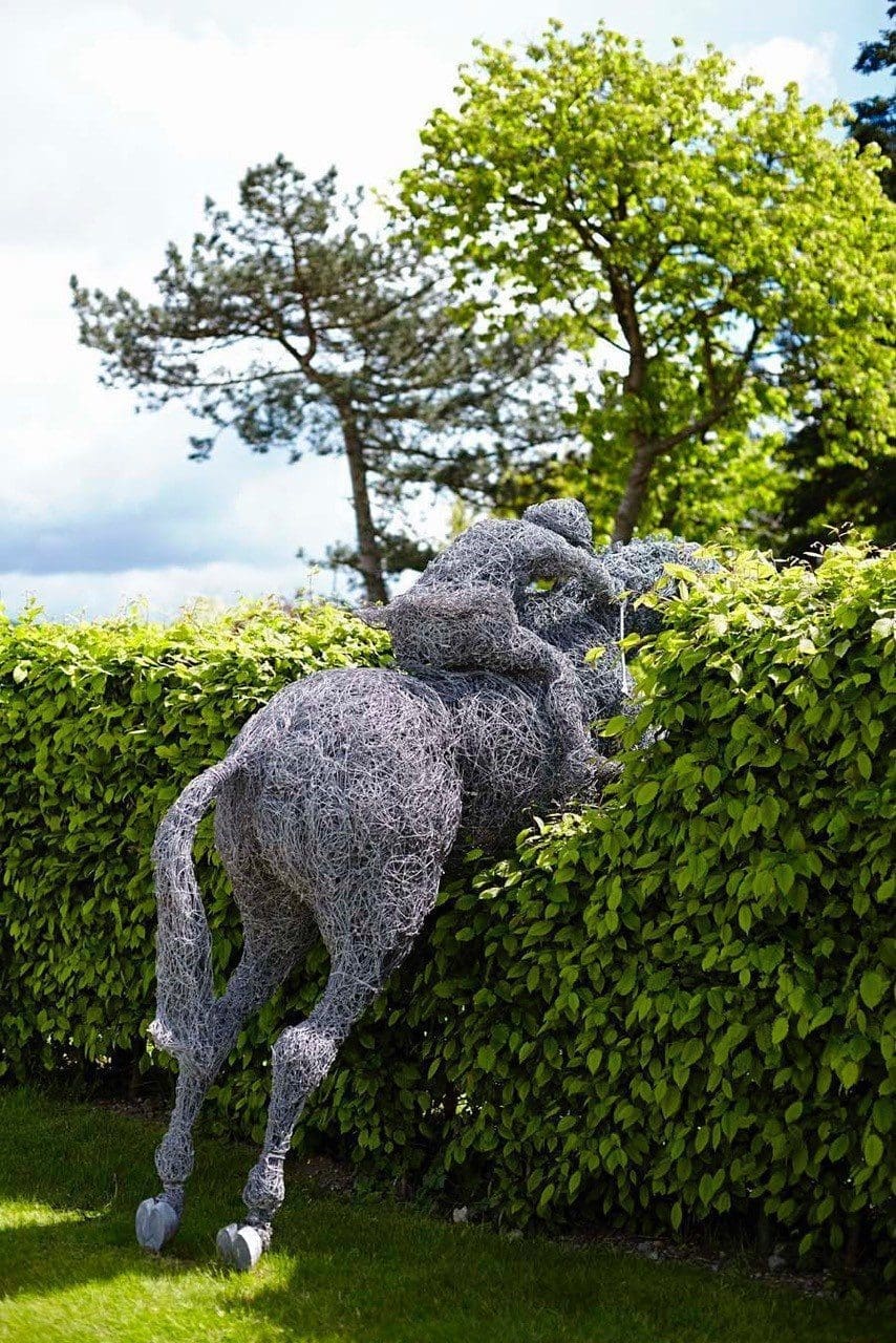 Lifesize wire sculpture of a jumping horse and rider by Rupert Till