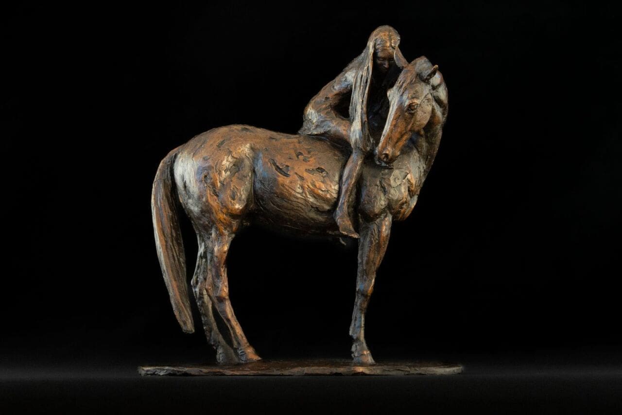 Bronze sculpture of a girl touching or standing beside a horse by Tanya Russell.