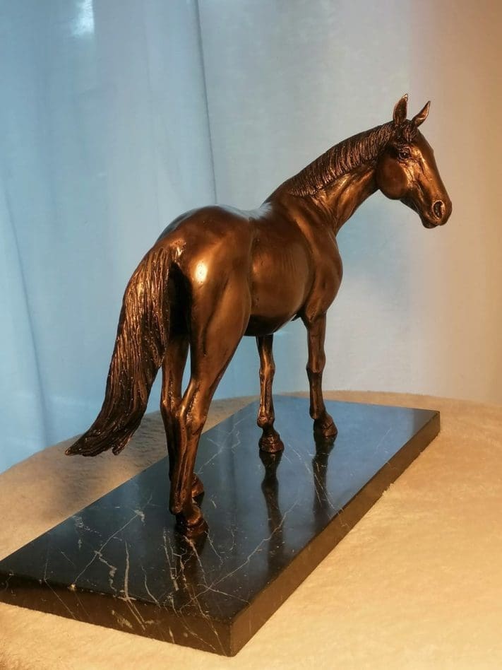 Bronze sculpture of a horse looking backward by Anna Tölgyesi Poós.