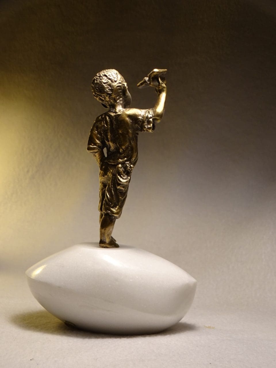 Freedom bronze sculpture of a boy playing with a paper airplane by Anna Tölgyesi Poós